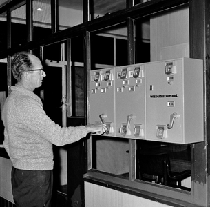 126617 Afbeelding van de wisselautomaat en postzegelautomaat in het noodpostkantoor aan de Mauritsstraat te ...